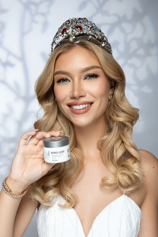 Miss Universe Hungary wearing her crown and holding Parisleaf Blemish Control Facial Cream.